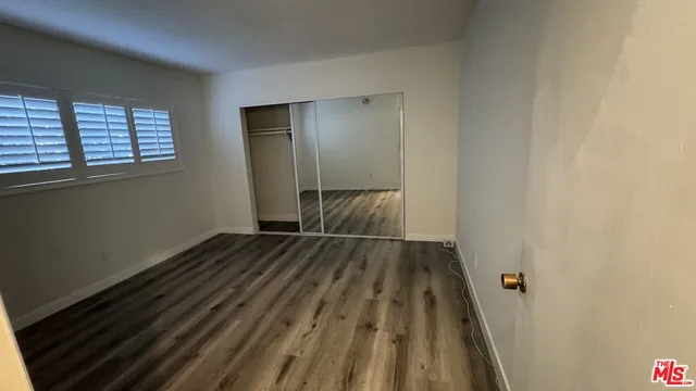 a view of a room with wooden floor and window