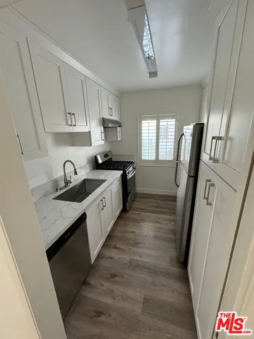a large kitchen with a sink a refrigerator and dishwasher