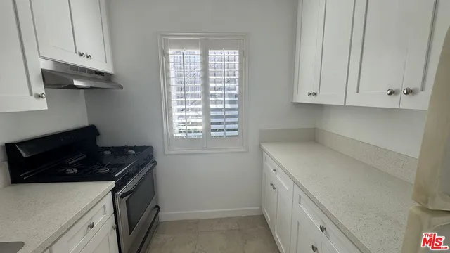 a utility room with granite countertop a sink a stove and a refrigerator