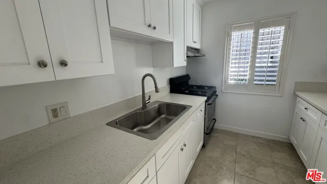 a kitchen with stainless steel appliances a sink a stove and cabinets