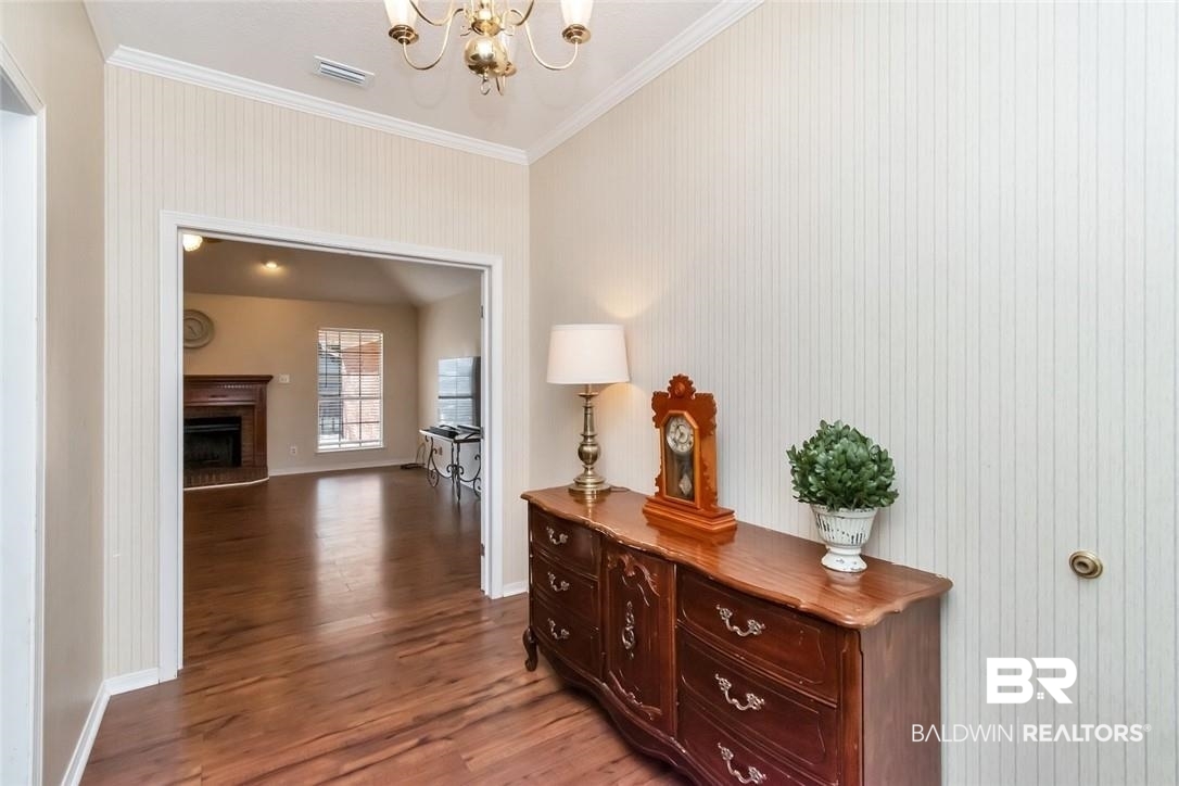 6601 Conde Court Mobile, AL 36695 - Photo 5 of 30 Corridor with a chandelier, crown molding, and hardwood / wood-style flooring
