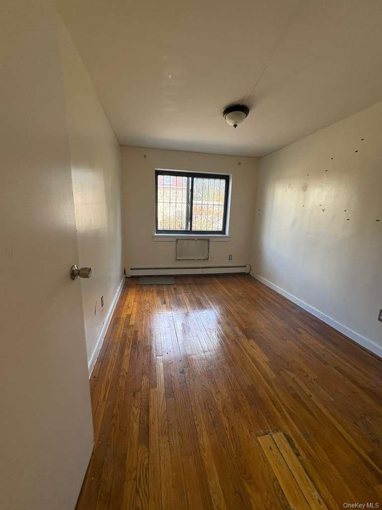 34-53 106th Street, Unit 1 Queens, NY 11368 - Photo 1 of 1 an empty room with wooden floor and windows