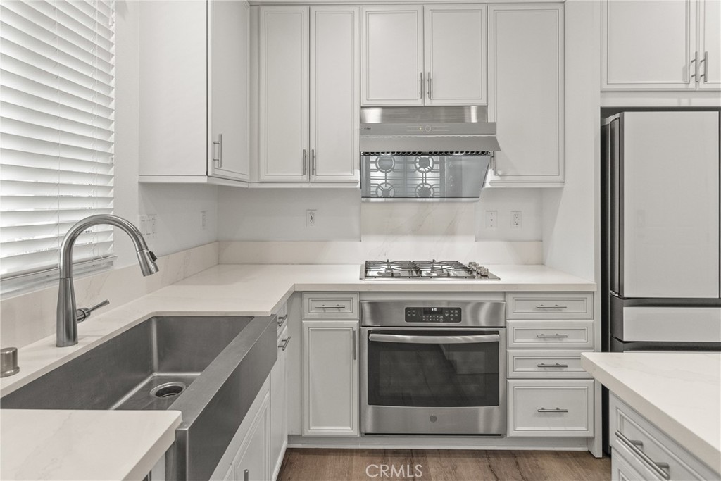 8743 Celebration Street Chino, CA 91708 - Photo 6 of 42 a kitchen with granite countertop white cabinets and stainless steel appliances