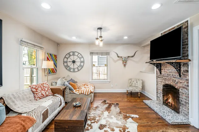a living room with furniture a fireplace and a flat screen tv
