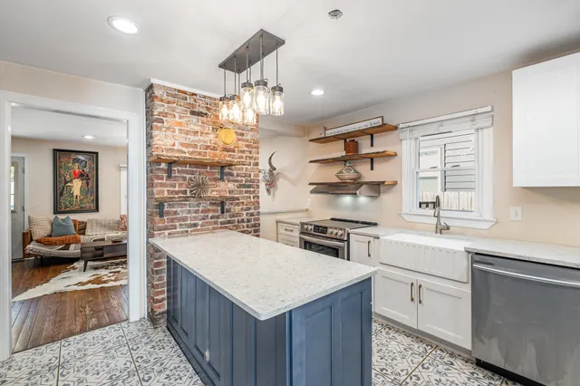 a kitchen with granite countertop a sink stove and cabinets