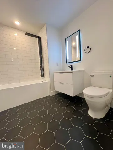 a bathroom with a toilet a sink and a mirror