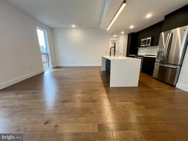 a view of a kitchen with stainless steel appliances a refrigerator and a stove top oven