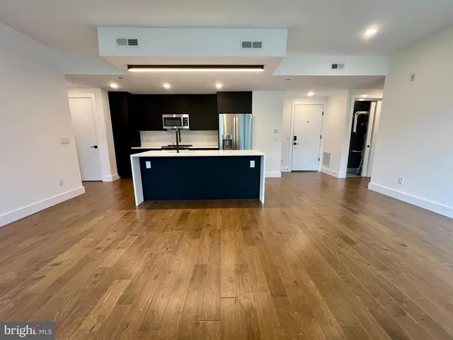 a view of kitchen and living room with wooden floor