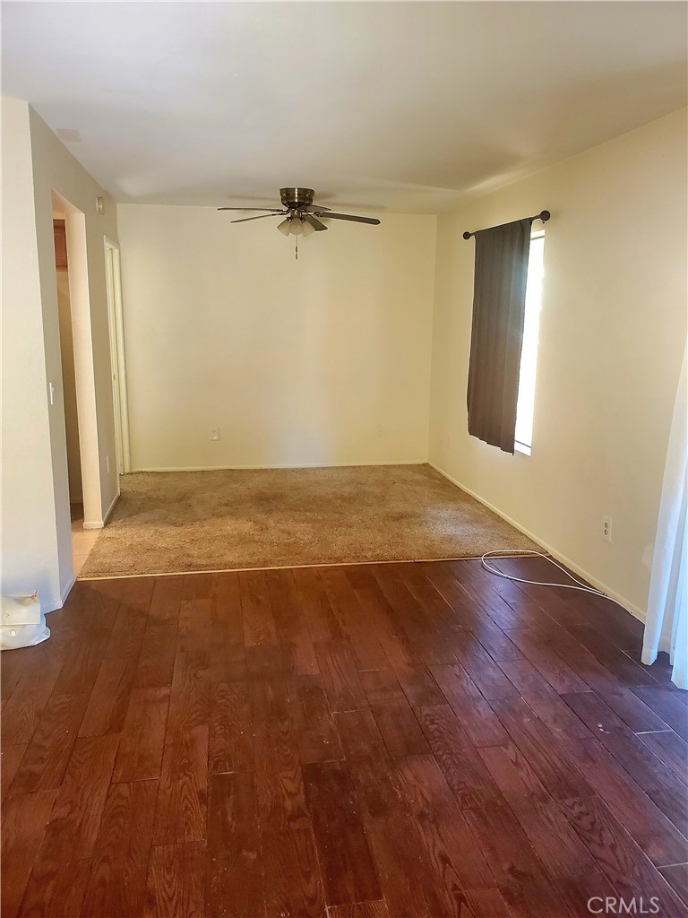 1110 West Blaine Street, Unit 107 Riverside, CA 92507 - Photo 7 of 34 an empty room with wooden floor and windows