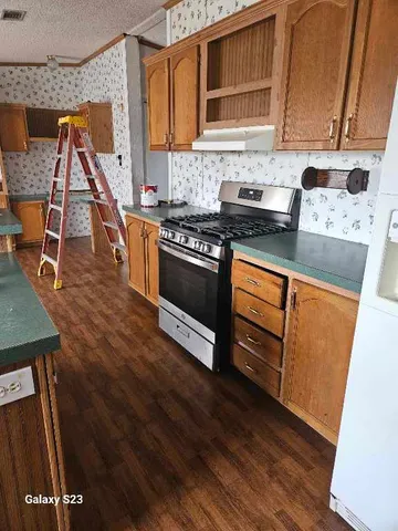 a kitchen with stainless steel appliances granite countertop a stove a sink and a refrigerator