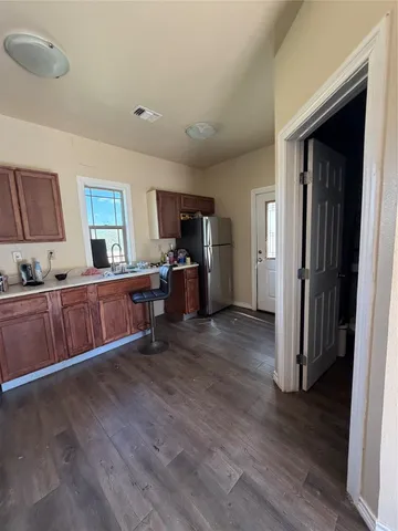 a view of a kitchen with furniture and wooden floor