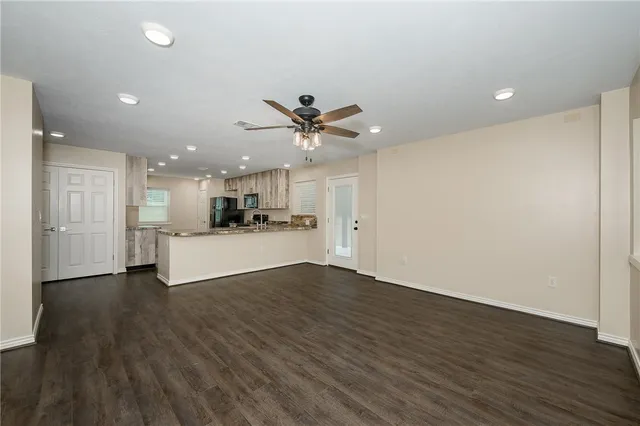 a view of a livingroom with a kitchen counter tops and wooden floor