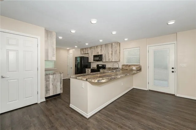 a kitchen with stainless steel appliances granite countertop a white stove top oven and white cabinets