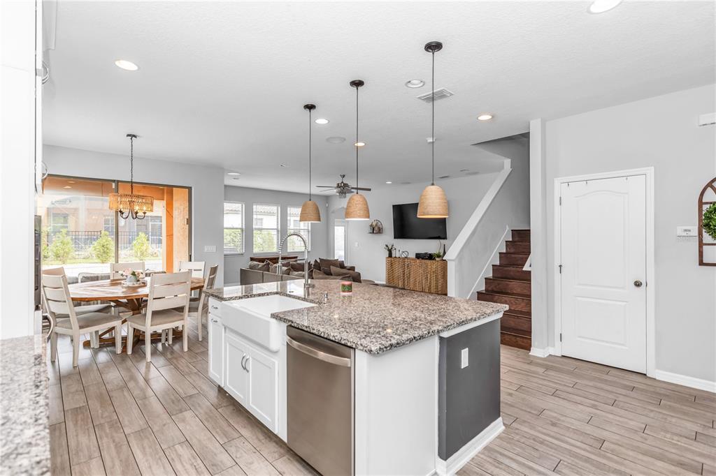 239 Lugano Way DeBary, FL 32713 - Photo 11 of 52 a open kitchen with a table chairs stove and wooden floor