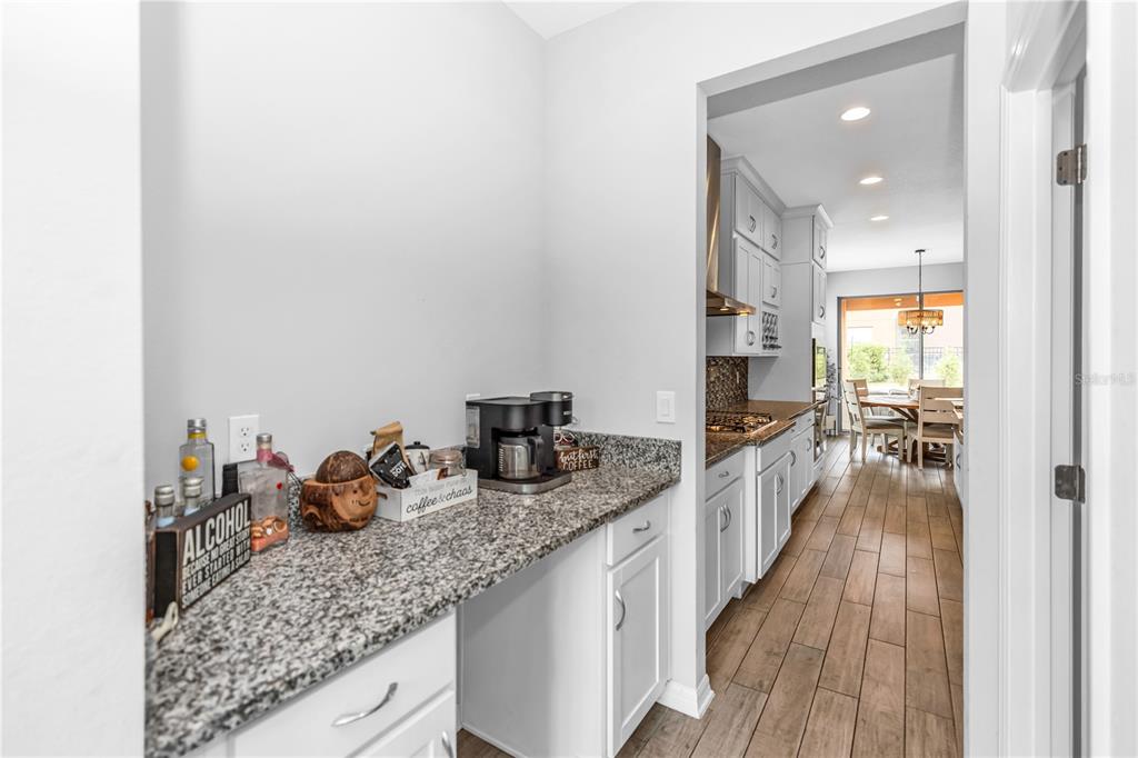 239 Lugano Way DeBary, FL 32713 - Photo 13 of 52 a kitchen with sink refrigerator and wooden floor