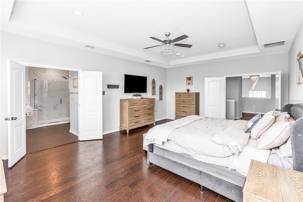 239 Lugano Way DeBary, FL 32713 - Photo 22 of 52 a spacious bedroom with a bed and a flat screen tv
