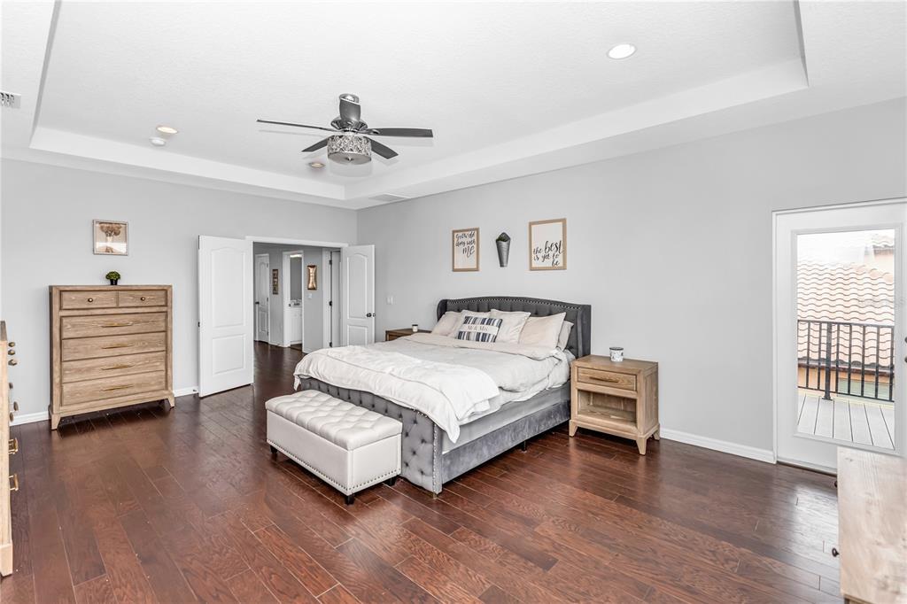 239 Lugano Way DeBary, FL 32713 - Photo 23 of 52 a spacious bedroom with a bed a dresser and wooden floor