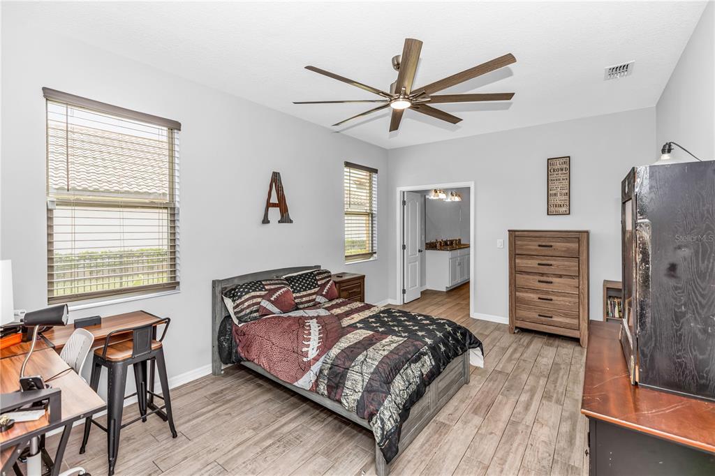 239 Lugano Way DeBary, FL 32713 - Photo 27 of 52 a bedroom with a bed and wooden floor