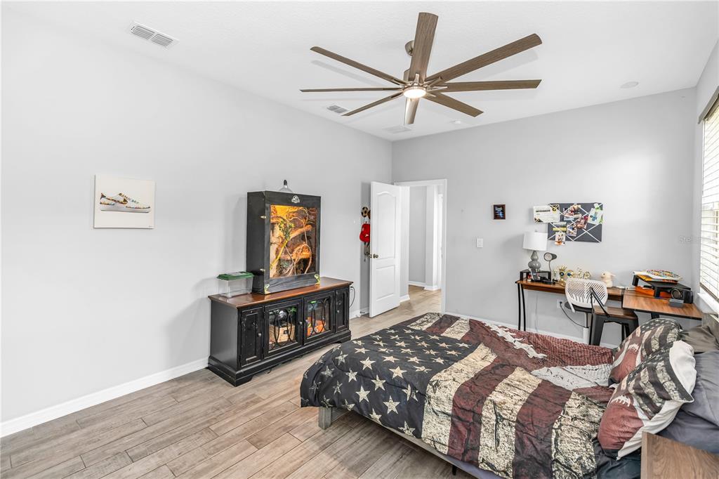239 Lugano Way DeBary, FL 32713 - Photo 28 of 52 a bedroom with a bed and wooden floor