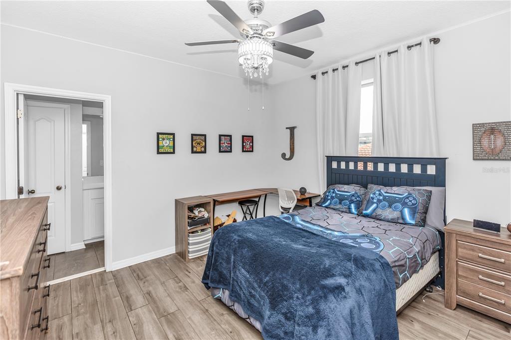 239 Lugano Way DeBary, FL 32713 - Photo 31 of 52 a bedroom with a large bed and a chandelier
