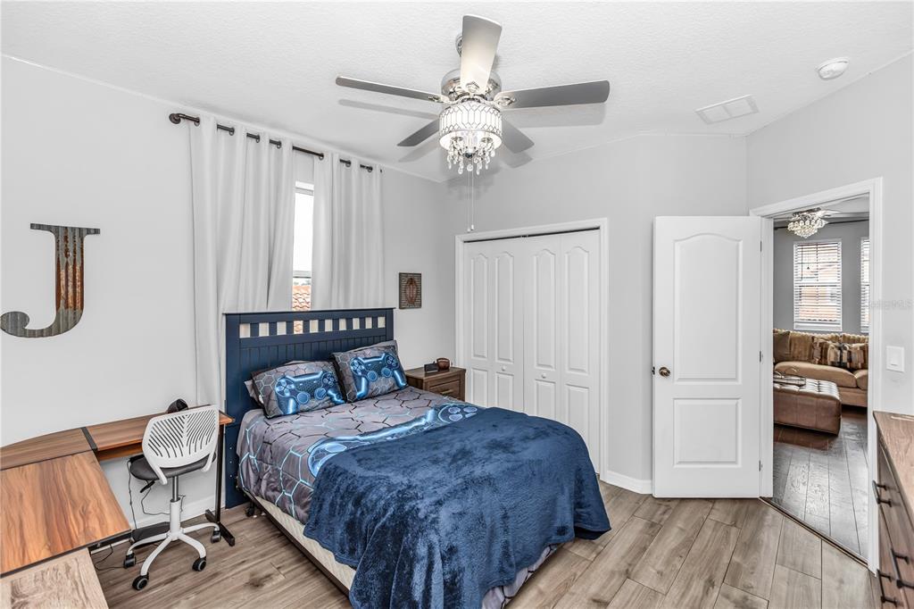 239 Lugano Way DeBary, FL 32713 - Photo 32 of 52 a bedroom with a bed and a chandelier