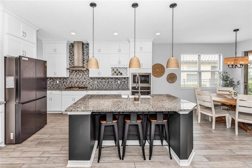 239 Lugano Way DeBary, FL 32713 - Photo 9 of 52 a kitchen with stainless steel appliances granite countertop a kitchen island a stove and a wooden floors