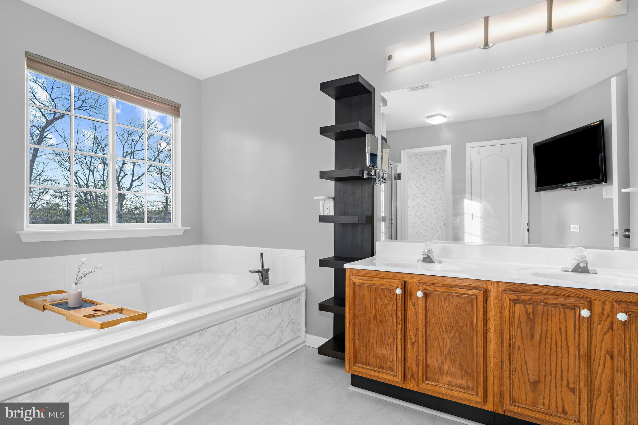13159 Partridge Berry Court Waldorf, MD 20601 - Photo 32 of 63 a bathroom with a tub sink and mirror