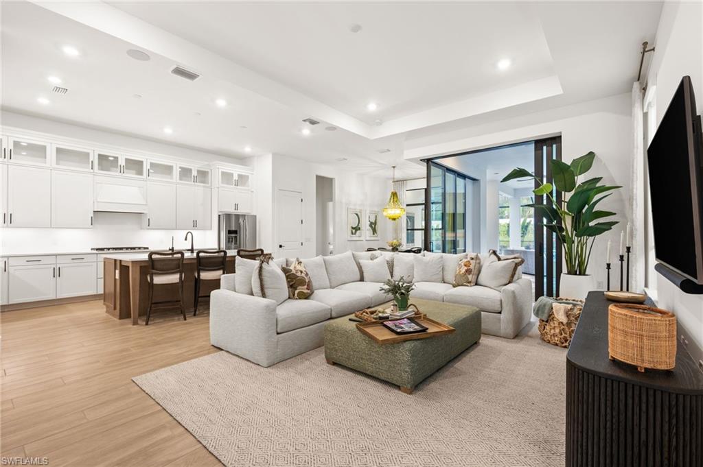 9565 Caymas Terrace Naples, FL 34114 - Photo 12 of 47 a living room with furniture kitchen view and a flat screen tv