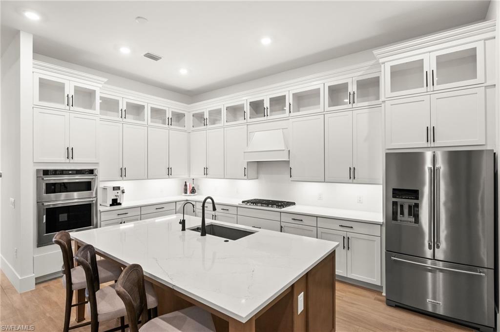 9565 Caymas Terrace Naples, FL 34114 - Photo 14 of 47 a kitchen with a refrigerator a stove a sink and a dining table
