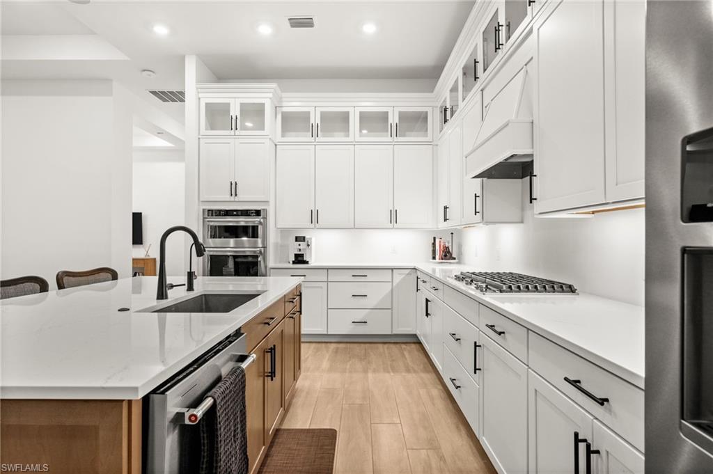 9565 Caymas Terrace Naples, FL 34114 - Photo 16 of 47 a kitchen with stainless steel appliances granite countertop a sink stove and cabinets