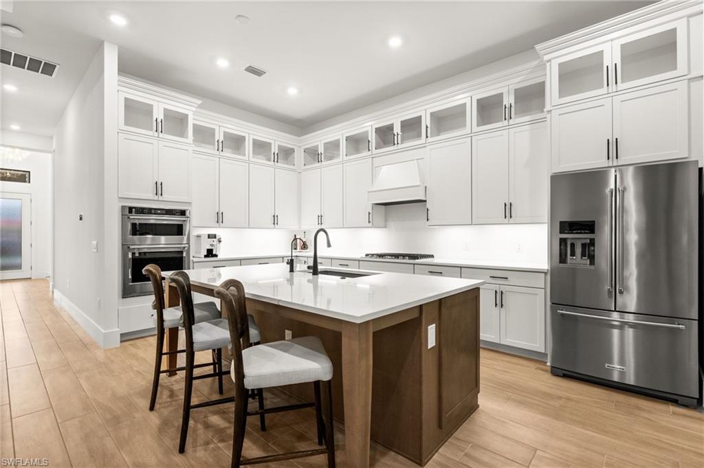 9565 Caymas Terrace Naples, FL 34114 - Photo 18 of 47 a kitchen with stainless steel appliances granite countertop a stove and a refrigerator