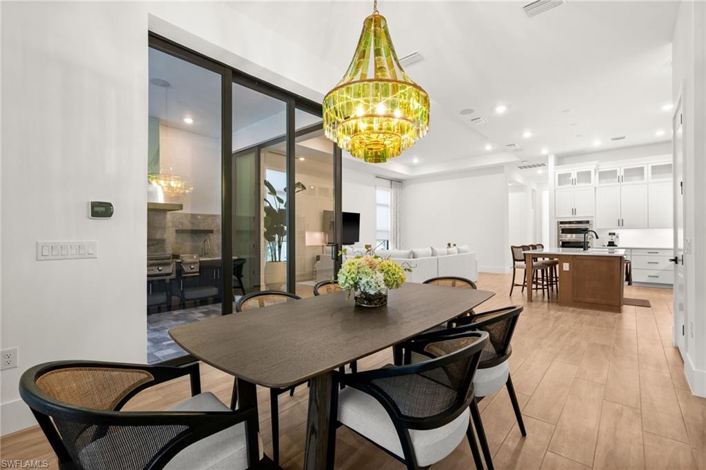 9565 Caymas Terrace Naples, FL 34114 - Photo 21 of 47 a view of a dining room with furniture and wooden floor