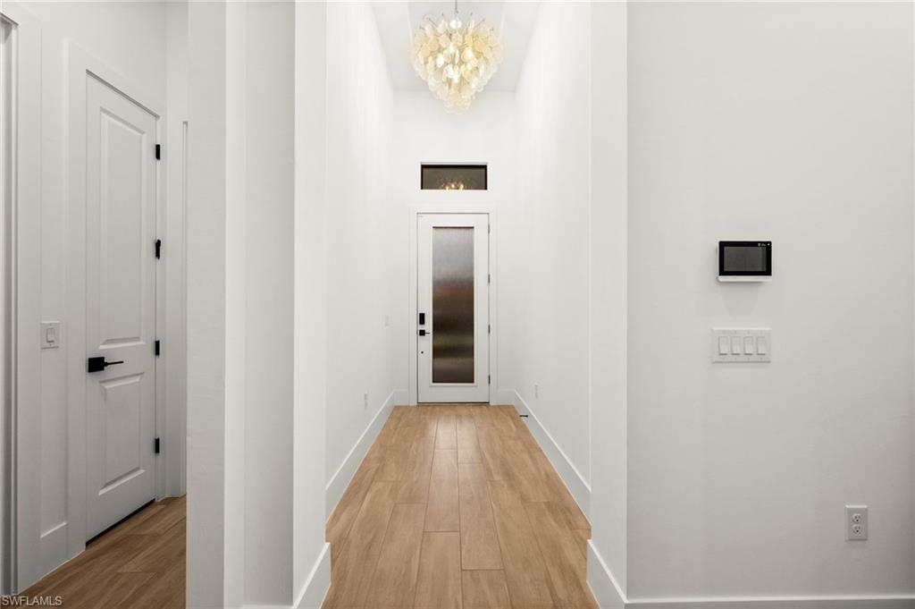 9565 Caymas Terrace Naples, FL 34114 - Photo 23 of 47 a view of a hallway with wooden floor and a bathroom