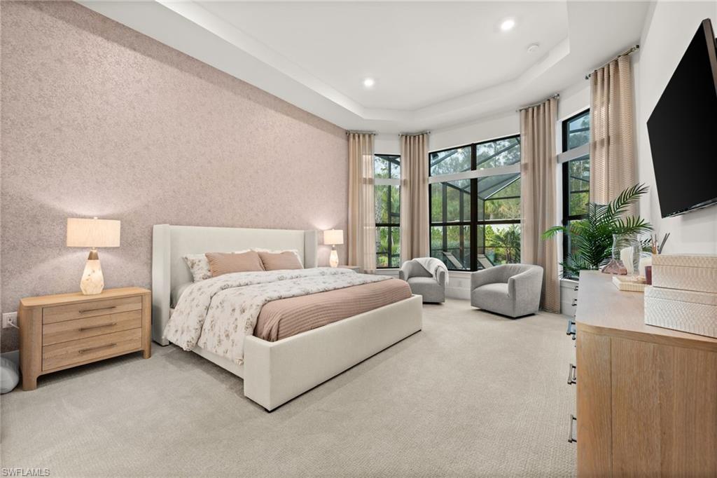 9565 Caymas Terrace Naples, FL 34114 - Photo 24 of 47 a spacious bedroom with a bed and a flat tv screen next to a window