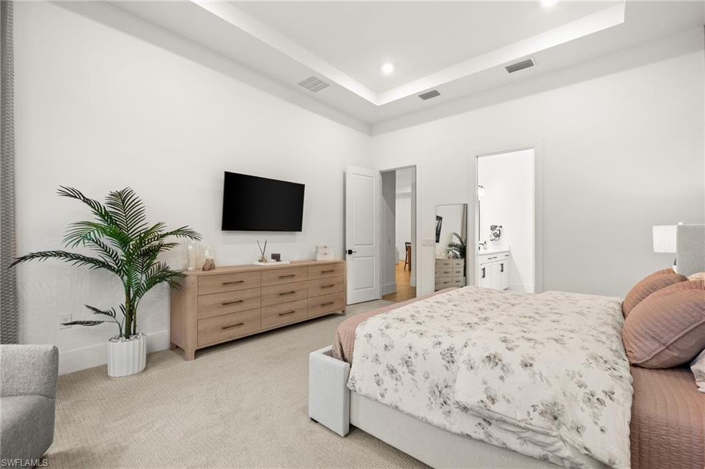9565 Caymas Terrace Naples, FL 34114 - Photo 26 of 47 a bedroom with a bed and a flat screen tv