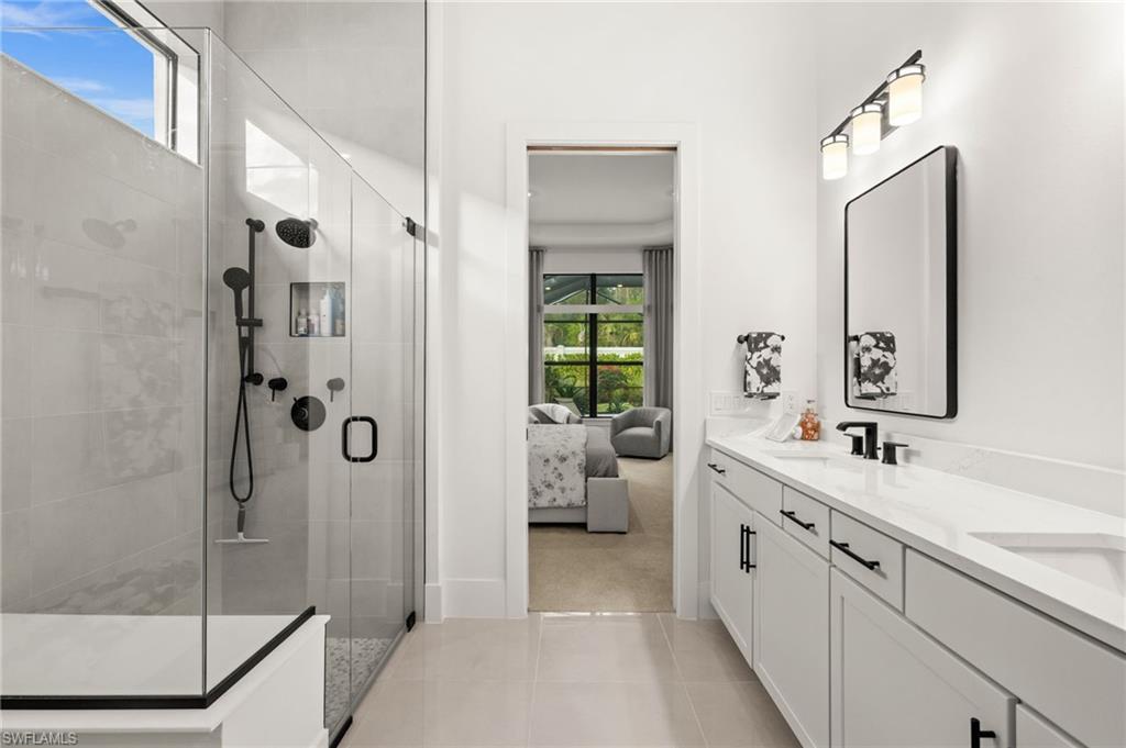 9565 Caymas Terrace Naples, FL 34114 - Photo 28 of 47 a spacious bathroom with a shower sink and mirror