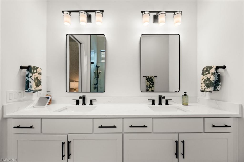 9565 Caymas Terrace Naples, FL 34114 - Photo 29 of 47 a bathroom with double vanity sinks and two mirror