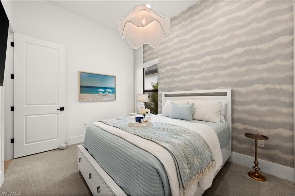9565 Caymas Terrace Naples, FL 34114 - Photo 31 of 47 a bedroom with a bed and a chandelier