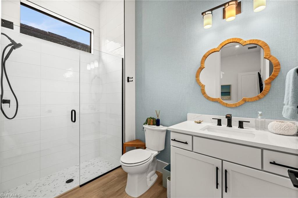 9565 Caymas Terrace Naples, FL 34114 - Photo 33 of 47 a bathroom with a toilet sink vanity and mirror