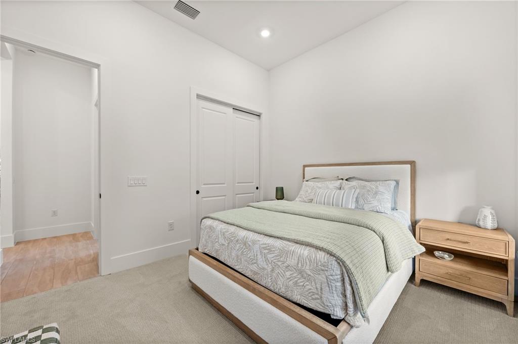 9565 Caymas Terrace Naples, FL 34114 - Photo 35 of 47 a bedroom with a bed and a night stand