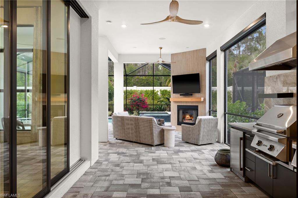 9565 Caymas Terrace Naples, FL 34114 - Photo 38 of 47 a living room with furniture a fireplace and a flat screen tv