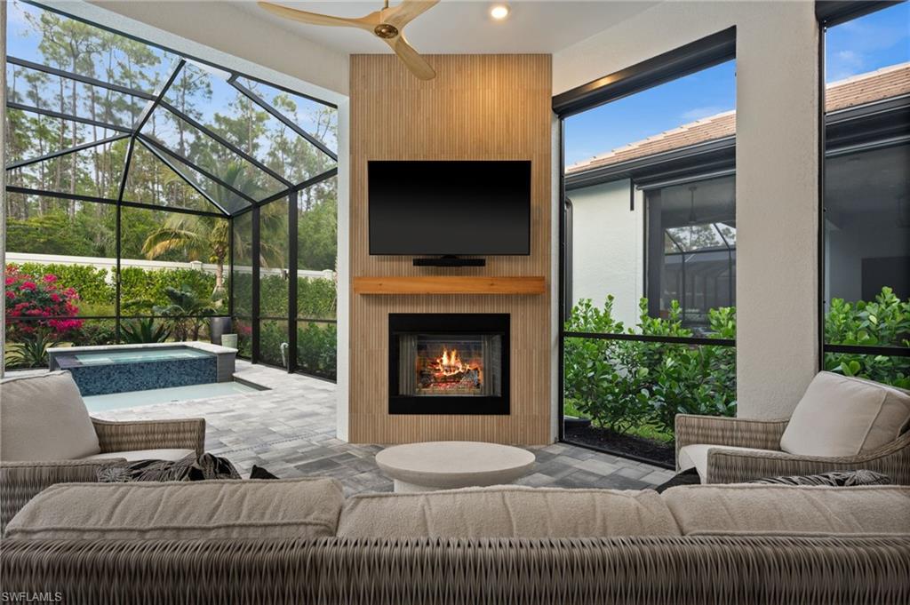 9565 Caymas Terrace Naples, FL 34114 - Photo 39 of 47 a living room with furniture a flat screen tv and a fireplace