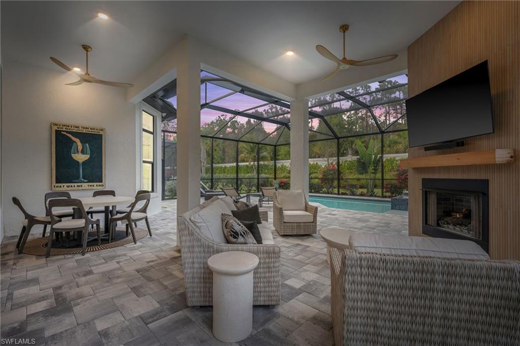 9565 Caymas Terrace Naples, FL 34114 - Photo 44 of 47 a living room with furniture a flat screen tv and a fireplace