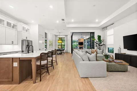 a living room with furniture a potted plant and a flat screen tv