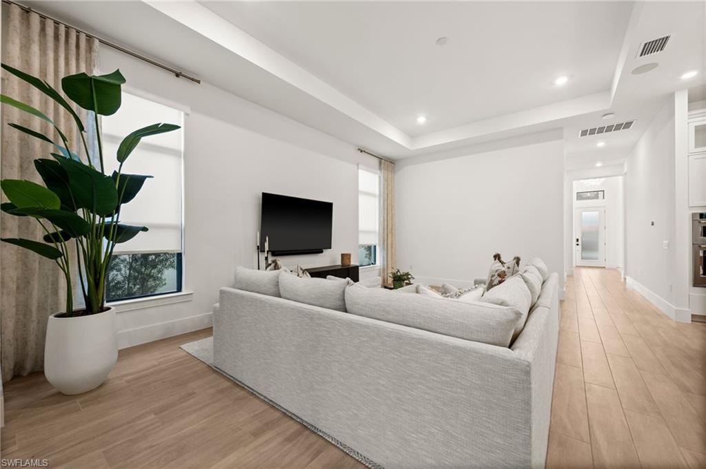 9565 Caymas Terrace Naples, FL 34114 - Photo 10 of 47 a living room with furniture a potted plant and a flat screen tv