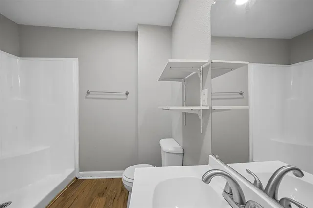 a bathroom with a toilet and a shower