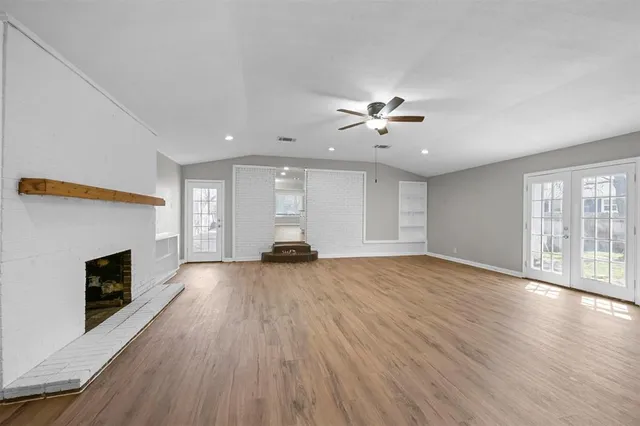a view of empty room with wooden floor and fireplace