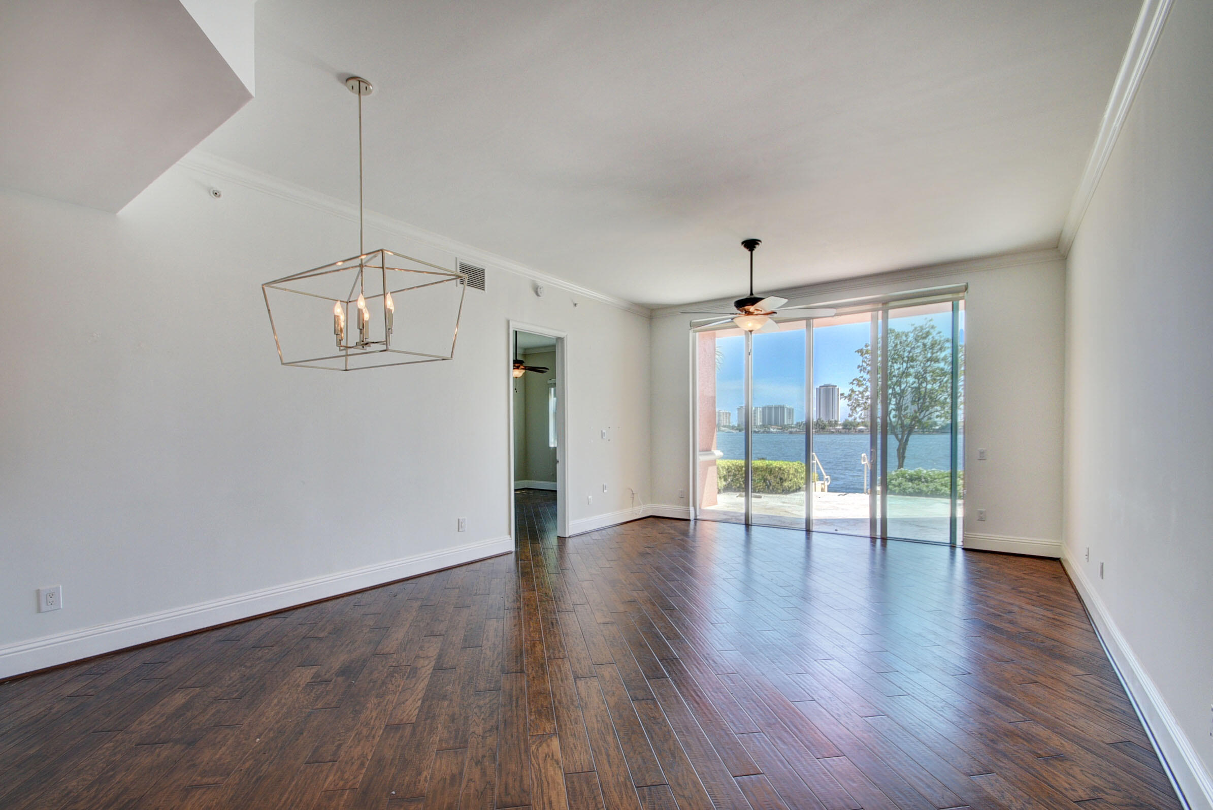 2640 Lake Shore Drive, Unit 115 Riviera Beach, FL 33404 - Photo 11 of 59 a view of an empty room with wooden floor and a window