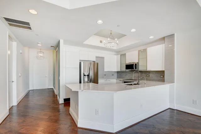 a kitchen with stainless steel appliances granite countertop a stove and a wooden floors