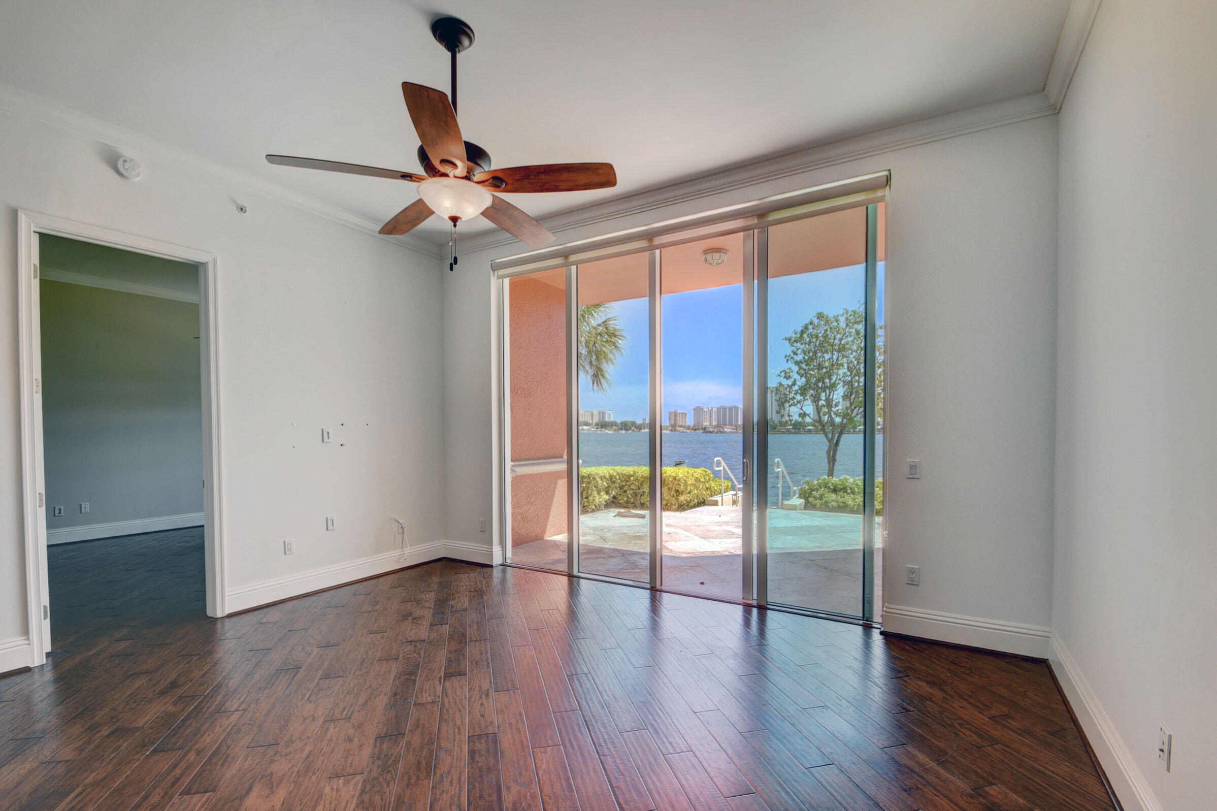 2640 Lake Shore Drive, Unit 115 Riviera Beach, FL 33404 - Photo 14 of 59 a view of an empty room with wooden floor and a window